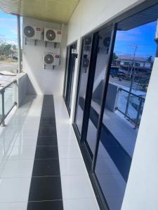 an empty hallway in a building with windows and a tiled floor at Calo apartel in Panabo