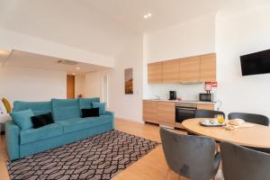 a living room with a blue couch and a table at Romantic Douro River & Sunset views in Porto