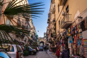 uma rua estreita com edifícios e pessoas a andar por ela em Le Mura Antiche em Nápoles