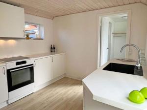 een witte keuken met een wastafel en een fornuis bij Holiday home Allinge CCCXXXV in Allinge