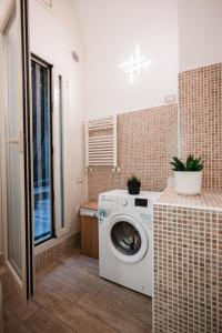y baño con lavadora y secadora de ropa y encimera. en Suite House 78, en Bari