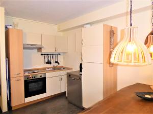 cocina con armarios blancos y nevera en Cityloft Winterberg Ferienwohnung Pool Sauna bis 5 Pers Balkon near Lift, en Winterberg