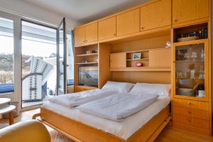 a bedroom with a large bed and a large window at Kniepsand in Hörnum