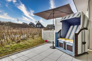 a hot dog stand with an umbrella on a patio at Kniepsand in Hörnum