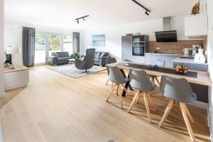 cocina y sala de estar con mesa y sillas en Wolkenlos en Norderney