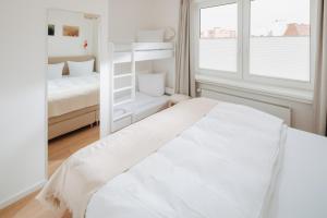 Habitación blanca con cama y ventana en Villa Fresena Bude 9, en Norderney