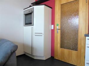 una nevera blanca en una habitación junto a una puerta en Cityview Winterberg Ferienwohnung in der City, en Winterberg 5 fotos más