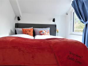 - un lit rouge dans une chambre avec fenêtre dans l'établissement AwayHome Winterberg Ferienwohnung Pool Sauna 5 Pers Wifi near Bikepark Switch Terrasse, à Winterberg 32 autres photos