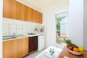 a kitchen with a bowl of fruit on a table at Seaside secluded apartments Cove Sutmiholjska, Mljet - 22318 in Blato