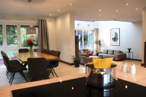 a kitchen and living room with a table and chairs at Das Rosenhaus - luxoriöses Ferienhaus mit viel Platz für die ganze Familie von "Momentic" in Timmendorfer Strand