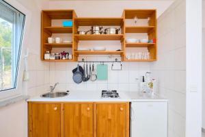 a kitchen with wooden cabinets and a sink at Seaside secluded apartments Cove Sutmiholjska, Mljet - 22318 in Blato +9 photos
