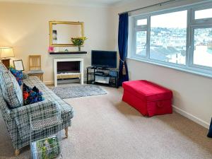 uma sala de estar com um sofá e um banco vermelho em 9 Dolphin Court em Brixham