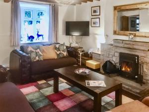 a living room with a couch and a fireplace at Bryn Euryn Cottage - 28135 in Llandrillo-yn-Rhôs