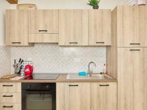 a kitchen with wooden cabinets and a sink at Apartments with a parking space Babino Polje, Mljet - 22321 in Babino Polje