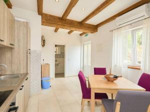 a kitchen and dining room with a table and purple chairs at Apartments with parking spaces Babino Polje, Mljet - 22321 in Babino Polje
