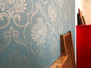 a wall with a blue and white damask wallpaper at Rosinas - Alte Küche in Oberstaufen