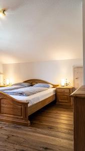 1 dormitorio con 1 cama de madera y 2 mesitas de noche en Seelenruhe, en Oberstaufen