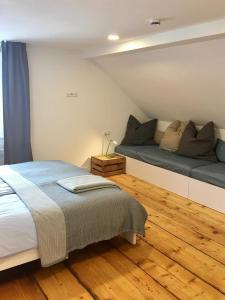 um quarto com uma cama grande e piso em madeira em Rosinas - Fräulein Thäsler em Oberstaufen