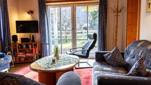 - un salon avec un canapé, des chaises et une table dans l'établissement FEWO Marion, à Oberstaufen