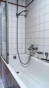 a bathroom with a bath tub with a shower at FEWO Marion in Oberstaufen +11 photos