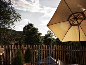 un parapluie assis au-dessus d'une clôture en bois dans l'établissement Rosinas - Christian, à Oberstaufen