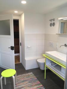 a bathroom with a sink and a toilet and a stool at Rosinas - Fräulein Winkler in Oberstaufen