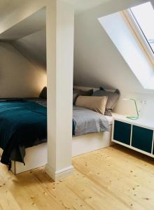 a attic bedroom with a bed and a desk at Rosinas - Fräulein Winkler in Oberstaufen