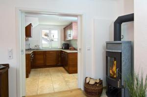 a living room with a fireplace and a kitchen at Alpenblick in Oberstaufen +1 photo