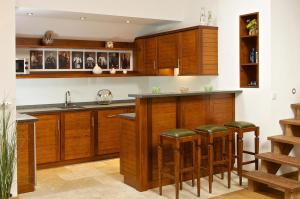 a kitchen with wooden cabinets and bar stools at Hochgrat in Oberstaufen