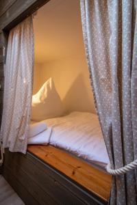 - un lit dans une chambre avec rideau dans l'établissement Butzenhuuske, à Krummhörn