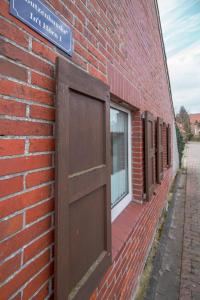une porte ouverte sur le côté d'un bâtiment en briques dans l'établissement Butzenhuuske, à Krummhörn