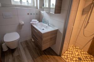 La salle de bains est pourvue d'un lavabo et de toilettes. dans l'établissement Butzenhuuske, à Krummhörn