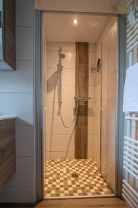 a bathroom with a shower with a glass door at Butzenhuuske in Krummhörn