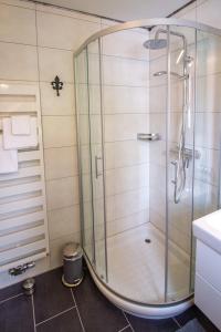 a shower with a glass door in a bathroom at Lüttje Scholle in Krummhörn