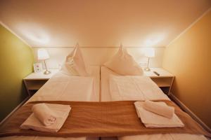 a large bed with white sheets and towels on it at Int Hörn 4 OG in Krummhörn