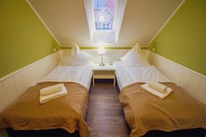 2 łóżka pojedyncze w pokoju z oknem w obiekcie Int Hörn 7 OG w mieście Krummhörn