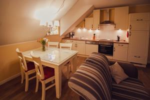 a kitchen and dining room with a table and a couch at Int Hörn 8 OG in Krummhörn