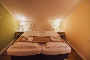 a large bed in a small room with two lamps at Int Hörn 8 OG in Krummhörn