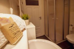 a bathroom with a toilet and a sign on a towel at Int Hörn 8 OG in Krummhörn +16 photos