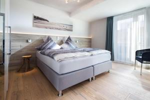 1 dormitorio con 1 cama grande en una habitación en Schippers Huus 04 - Bismarckloft, en Norderney