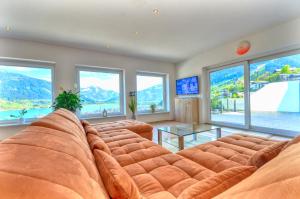 a large couch in a living room with windows at Eichenhof Top 2 - by Alpen Apartments in Zell am See