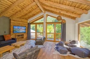 a living room with a couch and a tv at Chalet Schmitten - by Alpen Apartments in Zell am See