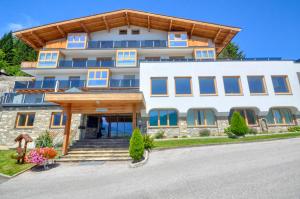 a large white building with blue windows at Eichenhof Top 2 - by Alpen Apartments in Zell am See