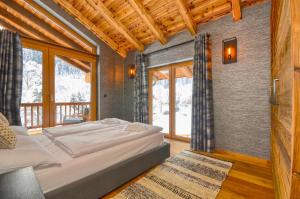 1 dormitorio con 1 cama grande en una habitación con ventanas en Chalet Schmitten - by Alpen Apartments en Zell am See