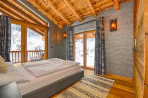 sypialnia z dużym łóżkiem w pokoju z oknami w obiekcie Chalet Schmitten - by Alpen Apartments w mieście Zell am See