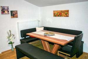 バードガシュタインにあるApartment Birke 1 - by Alpen Apartmentsのダイニングルーム(テーブル、黒い椅子2脚付)