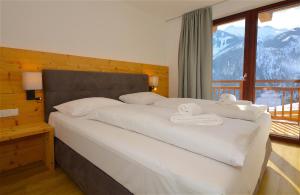 カプルーンにあるSki-in Ski-out Chalet Maiskogel "Bergli" - by Alpen Apartmentsのベッドルーム1室(大型ベッド1台、タオル付)