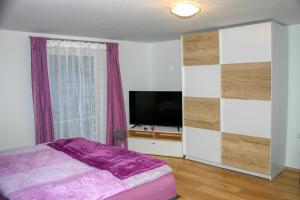 a bedroom with a bed and a flat screen tv at Apartment Birke 1 - by Alpen Apartments in Bad Gastein