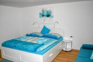 - une chambre avec un lit et des oreillers bleus dans l'établissement Apartment Birke 1 - by Alpen Apartments, à Bad Gastein