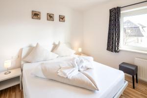 a white bed in a bedroom with a window at Mozart Top 1 - by Alpen Apartments in Zell am See